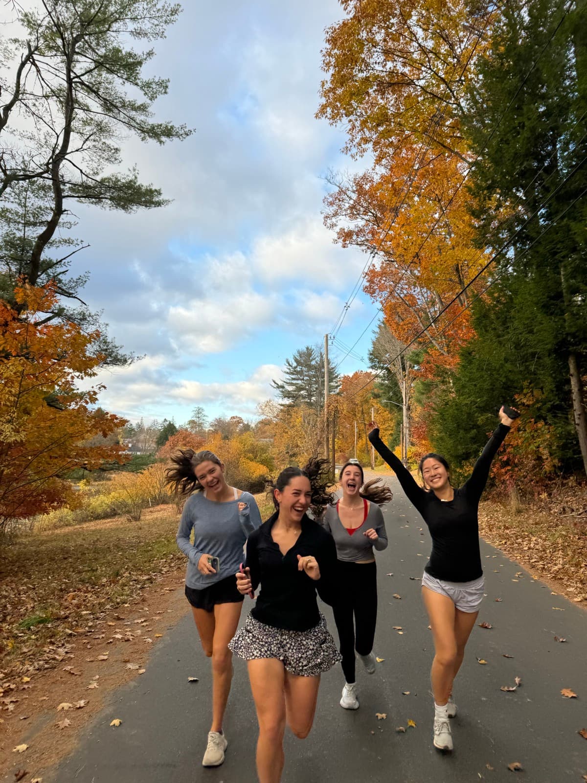 Four sisters running on a fall foliage path