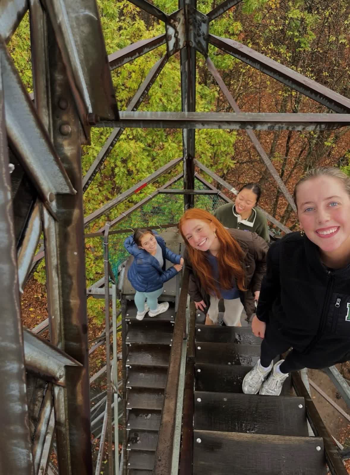 Sisters climbing a fire tower in the fall